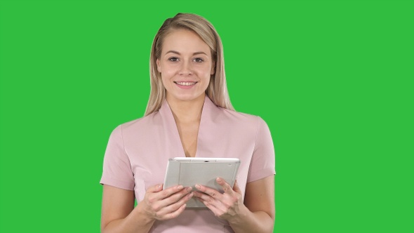 Middle shot of beautiful woman using tablet turning pages alt