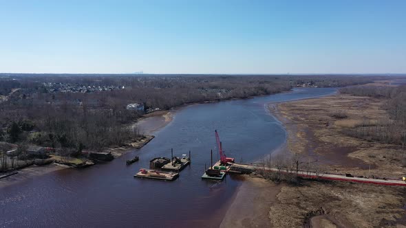 An aerial shot over a construction site in a creek. The camera truck left then pan right & finally d alt