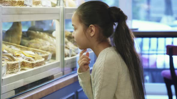 Cute Little Girl Looking at the Display at the Local Bakery alt