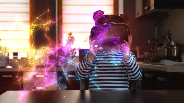 Child with Virtual Reality Headset Sitting Behind Table Indoors at Home alt