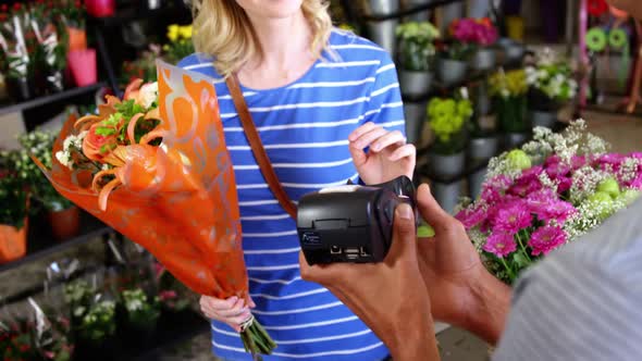 Costumer making payment through credit card in flower shop alt