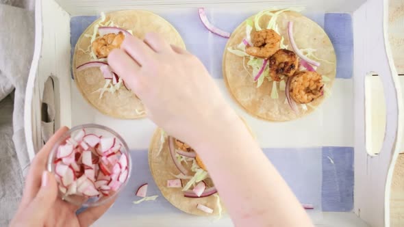 Fresh chipotle shrimp tacos with cotija cheese on a white corn tortillas. alt