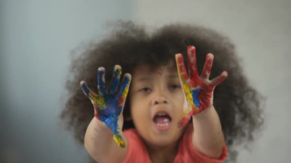 Cheerful Afro-American Girl Having Fun and Showing Painted Palms Into Camera alt
