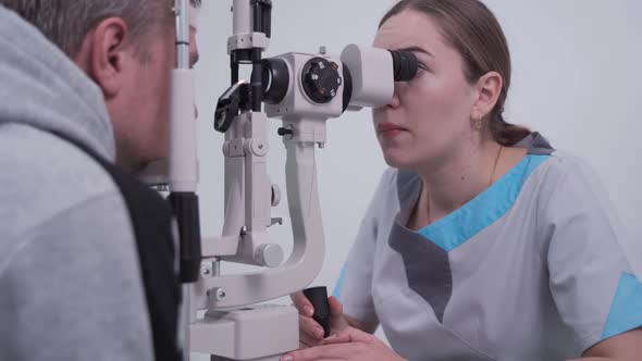 Optometrist Examining the Eyes of a Male Patient in a Modern Ophthalmology Clinic alt