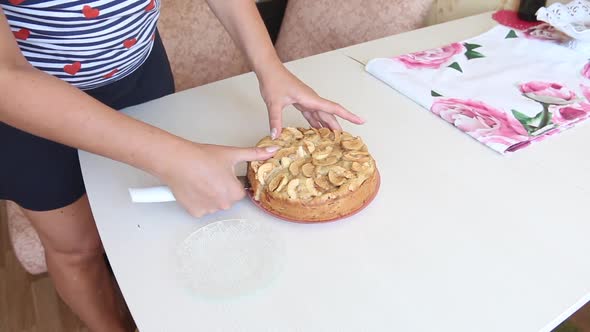 A Woman Cuts A Baked Apple Pie. Cooking Charlotte At Home. Shooting The Camera On The Slider.