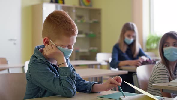 Video of bored boy sitting in a classroom during a pandemic. Shot with RED helium camera in 8K. alt