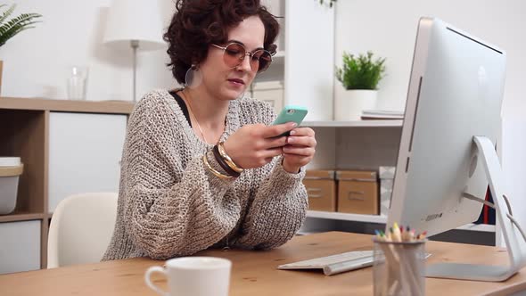 Young Woman Scrolling and Texting Using her Smartphone alt