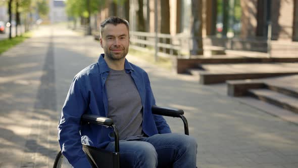 Portrait of the Happy Male Teacher on a Wheelchair Near School alt