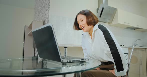 Delighted Young Woman Talks Looking Into Laptop Display alt