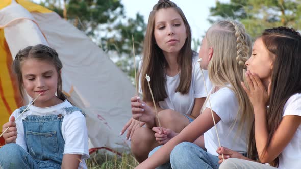 Teen Children Fry Marshmallows By the Fire on a Picnic They Have Fun in a Summer Camp alt