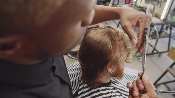 Black Barber Giving Haircut to Caucasian Client alt