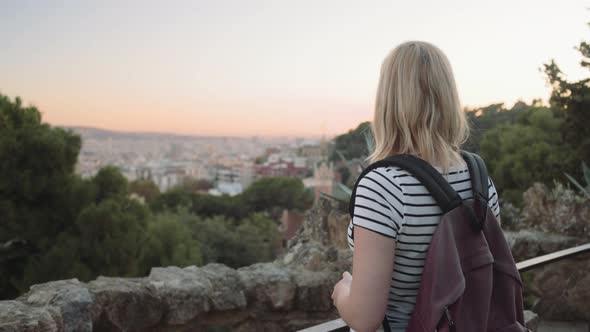 Young adult woman admiring view backpack in park Barcelona