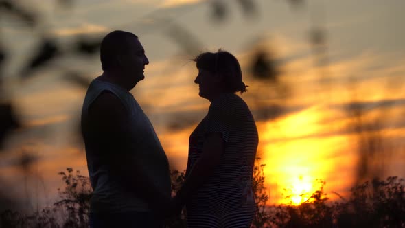 Man and Woman Facing Each Other On the Sunset Background