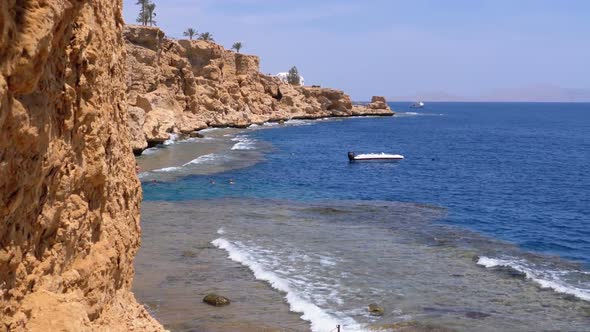 Rocky Beach in Egypt. Beach in a Bay on the Coastline with Waves in the Blue Sea and Coral Reefs alt