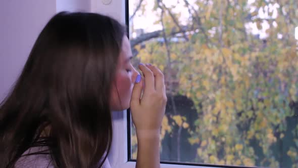 Beautiful teenage girl standing next to a window, daydreaming alt