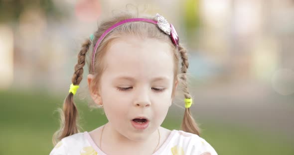 Charming Little Girl Blowing Dandelion While Walking