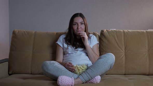 Lady Eats Popcorn and Rejoices Watching Competition on TV alt