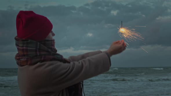 Woman On The Ocean Coast With Fireworks Sparkles