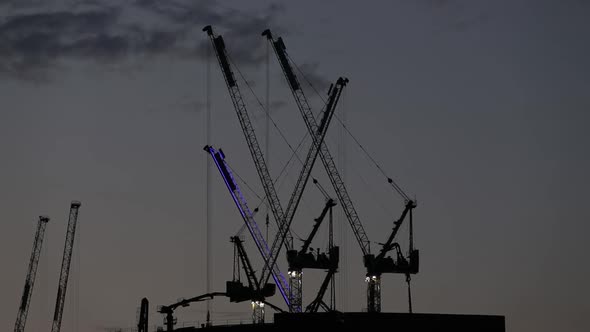 Construction Cranes in Action at Sunset