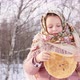 Cute girl in a traditional Russian headscarf with bagels eats pancake on winter background. - VideoHive Item for Sale