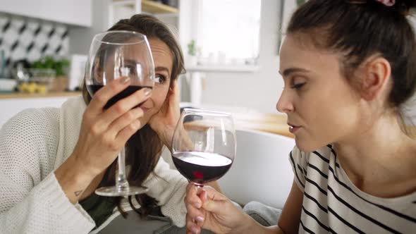 Zoom out video of two friends chatting and drinking wine. Shot with RED helium camera in 8K alt