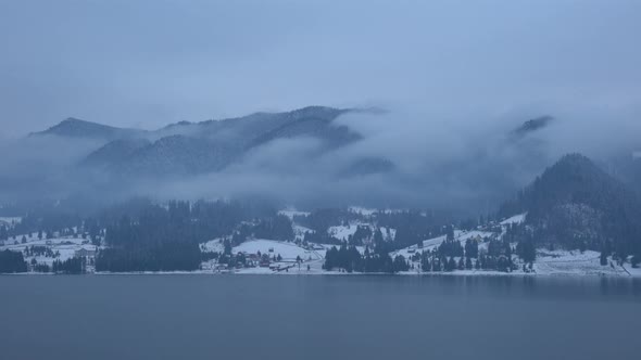 Misty mountains near a lake alt