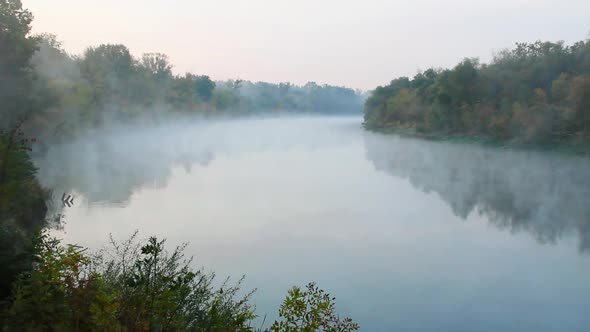 Smoke on the water. Fog floats over the river in the early morning at dawn. A beautiful lake