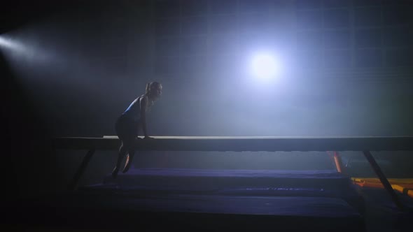 Teen Girl is Performing Tricks on Balance Beam in Gym Hall Training and Preparing to Competition alt