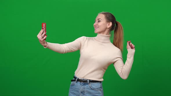 Happy Woman Taking Selfie on Green Screen alt