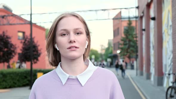 Young Woman with Short Fair Hair and Wireless Headphones alt