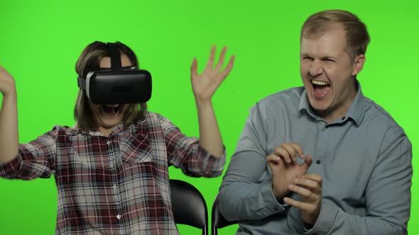 Man and Woman Using VR Headset Helmet To Play Game. Watching Virtual Reality 3D Video. Chroma Key alt