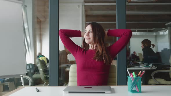 Smiling Satisfied Young Businesswoman Finished Computer Work Stretching Sitting at Workplace Desk at alt