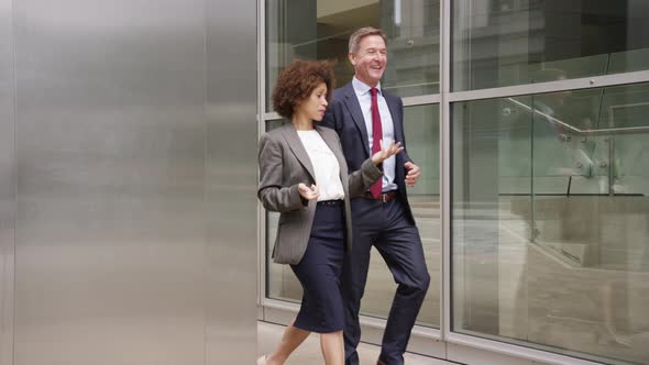 Businessman and businesswoman discussing work on the move