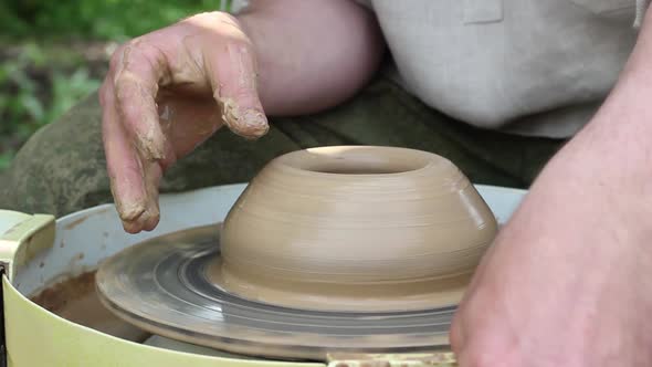 Male Potter of Caucasian Ethnicity Makes a Brown Clay Pot Moistens Clay and Draws a Mold alt