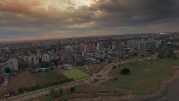 Cityscape under construction abutting waterfront beneath dramatic sky alt
