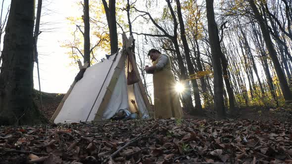 Woman standing by a canvas tent alt