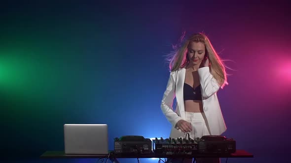 Beautiful, Sexy Dj Girl in White Jacket, Headphones Playing Music and Dancing, Hand in the Pocket alt