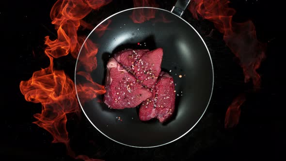 Super Slow Motion Shot of Throwing Beef Meat on Frying Pan and Fire Blast at 1000Fps alt