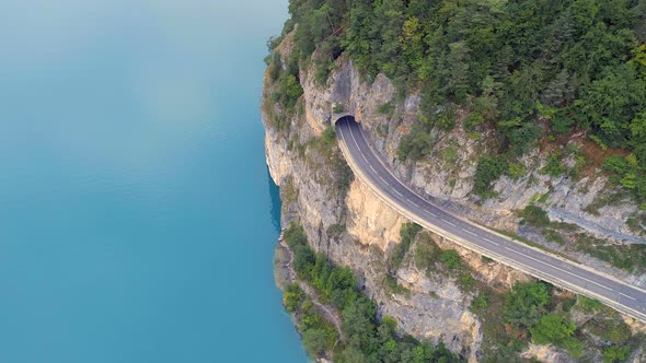 Mountain Road with Blue Lake Below and Tunnel alt