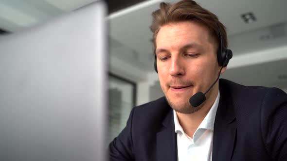 Businessman in the Office on the Phone with Headset