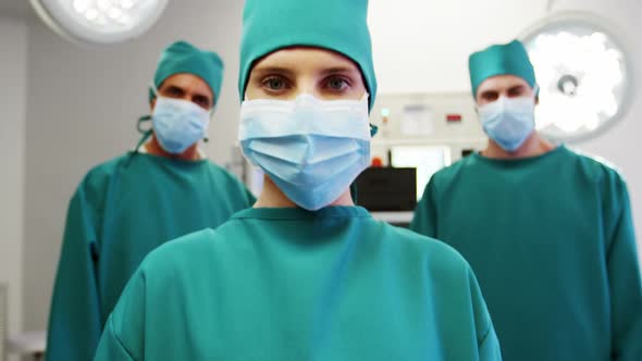 Portrait of medical team standing in operating room alt