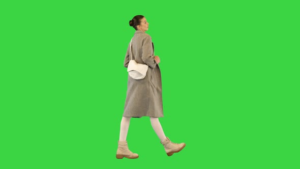 Young Woman in Casual Clothes Walks in Fashionable Manner on a Green Screen Chroma Key