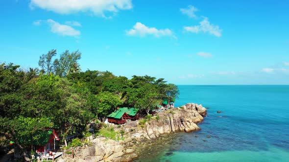 Aerial flying over sky of idyllic seashore beach journey by blue lagoon with white sandy background  alt