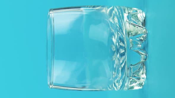 Vertical Video Closeup Shot of Milk Cold Beverage Drink Pooring Into Small Beautiful Glass Blue