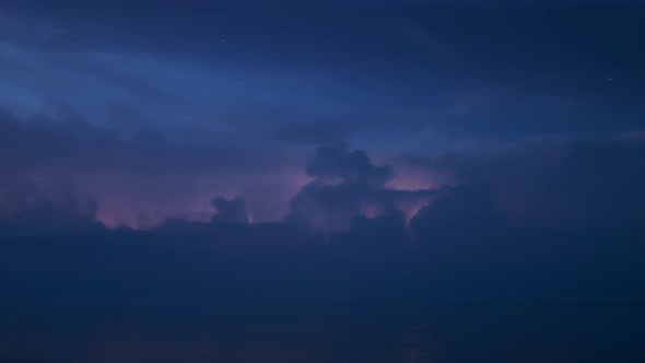 Night Thunderstorm with Many Lightning Bolts and Starry Sky Far on Horizon Above a Lake Timelapse