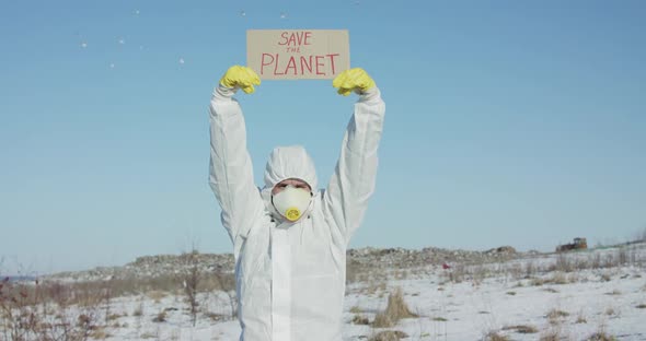 Man Wore in White Full Cover Suit Raises Protest Sign Save the Planet in Winter alt