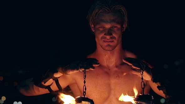 Young Blond Male Holds Two Pois Hanging on Chains Raises Them Then Lowers Them Face and Neck are alt