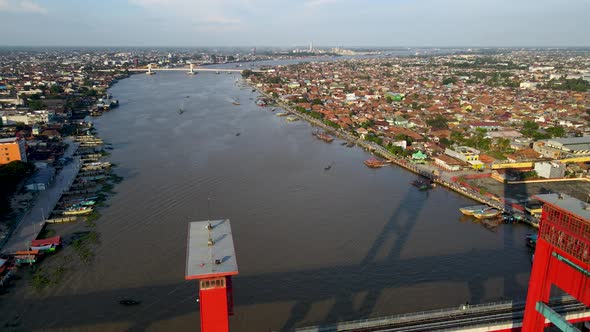 Cityscape of Palembang on sunny day with red color bridge of Ampera, aerial view alt