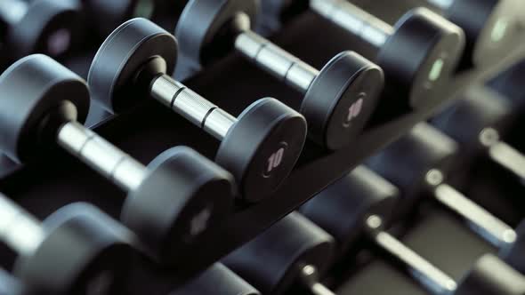 Endless rows of dumbbells on  rack in gym or fitness club. Strenght, fit concept alt