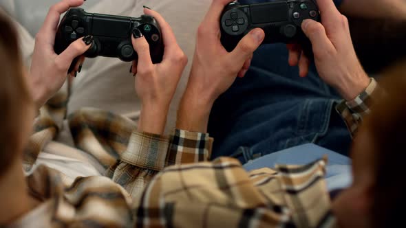 Players Hands Holding Gamepads Resting Home Closeup alt